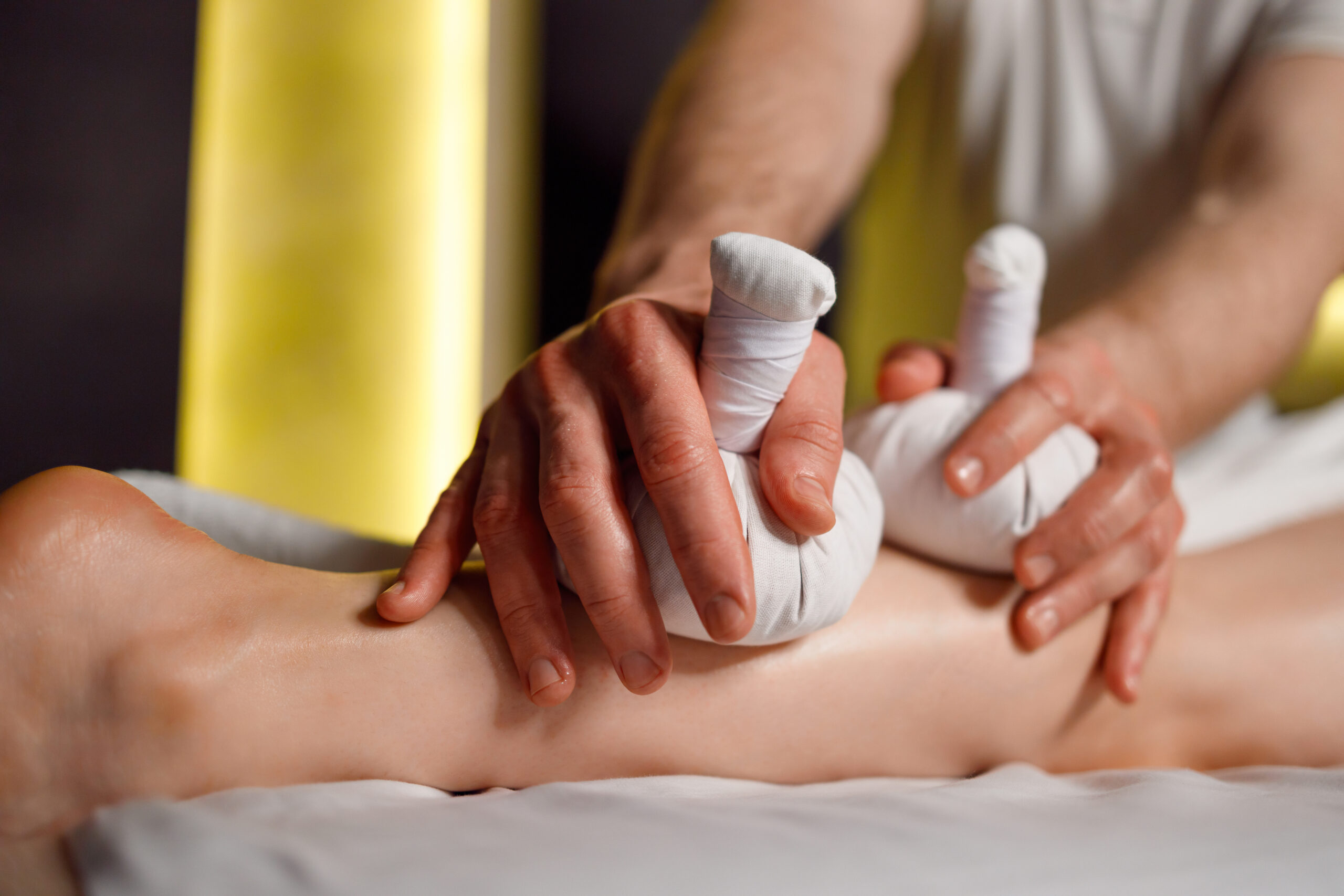 Foot massage with herbal bags in the spa salon